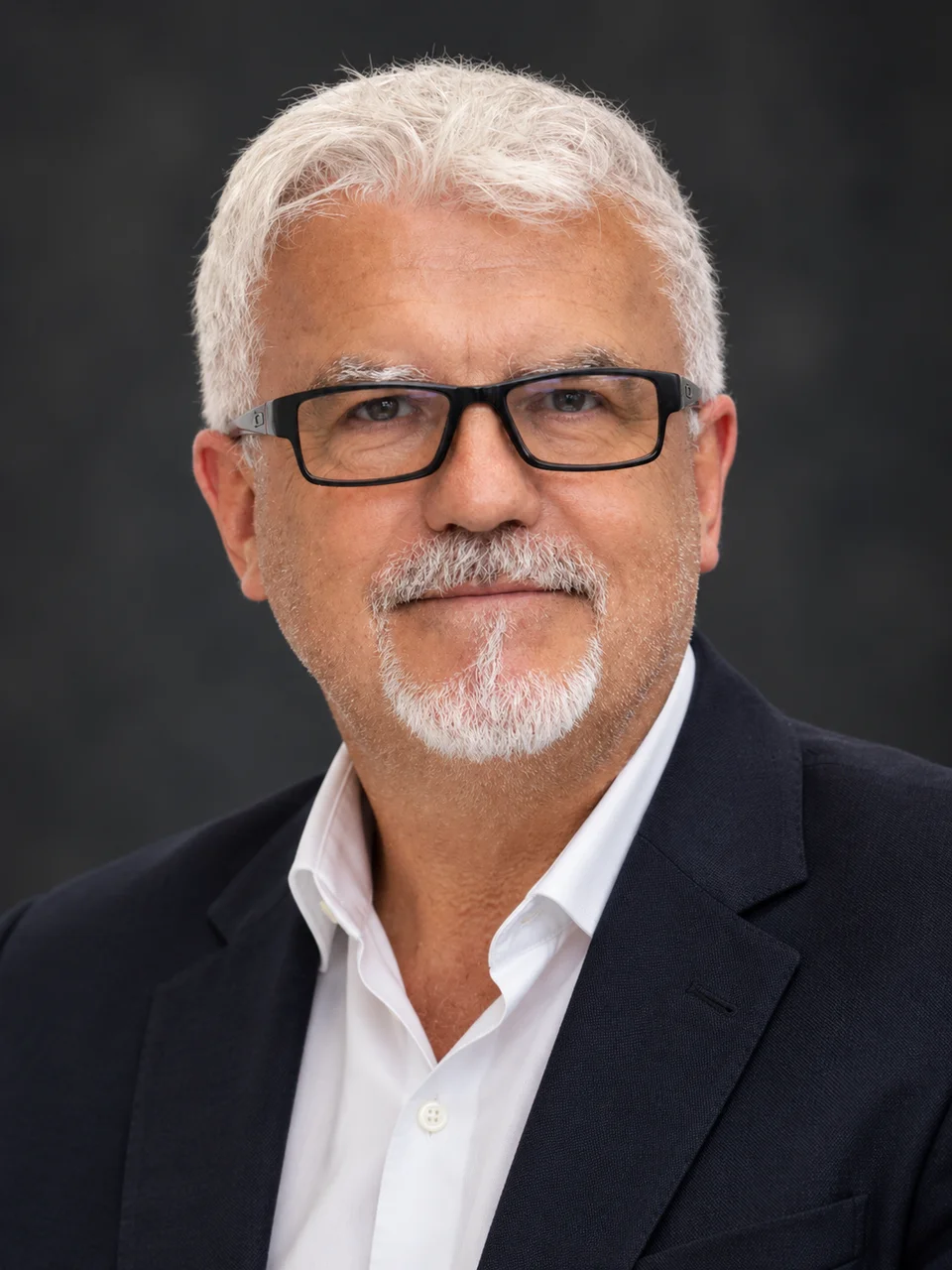 Portrait of Steve Munford wearing glasses and a dark jacket.